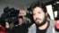 Reza Zarrab, a dual citizen of Turkey and his native Iran, is surrounded by journalists as he arrives at a police center in Istanbul in December 2013. Will his U.S. trial expose facts Turkey's president would rather not be made public?