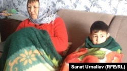 Жители села Акжол - пенсионерка Гульмира Сагиева со своим 8-летним внуком Арматом. ЗКО, 3 февраля 2015 года.
