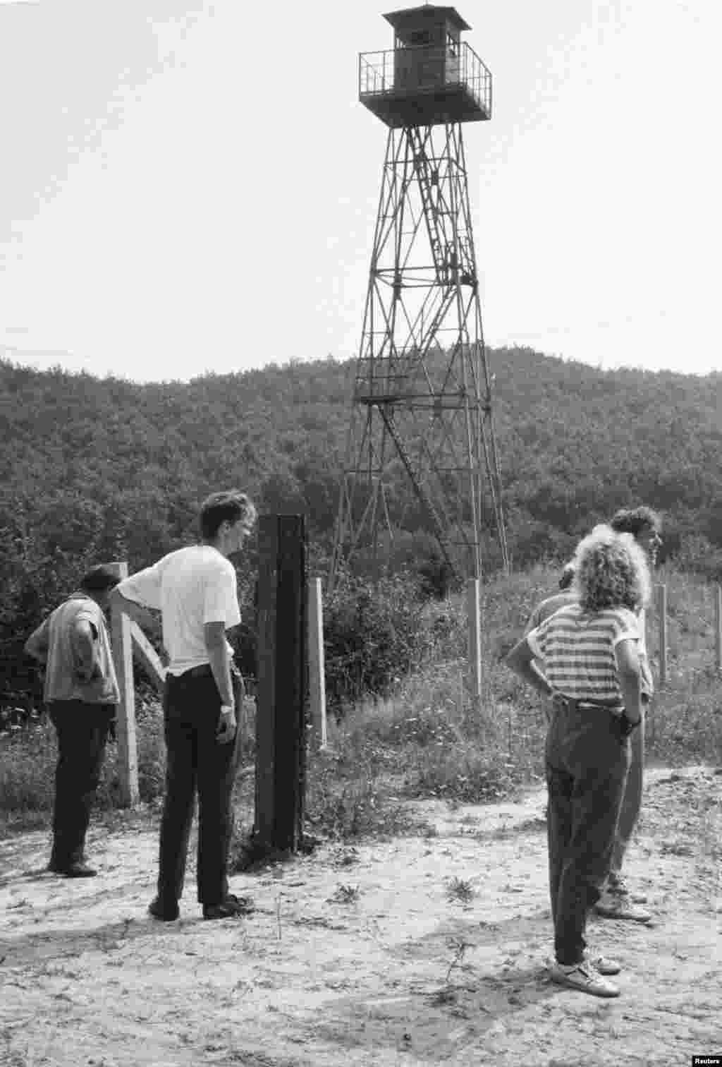 East German refugees observe the Austrian border within sight of a Hungarian watchtower on August 17.