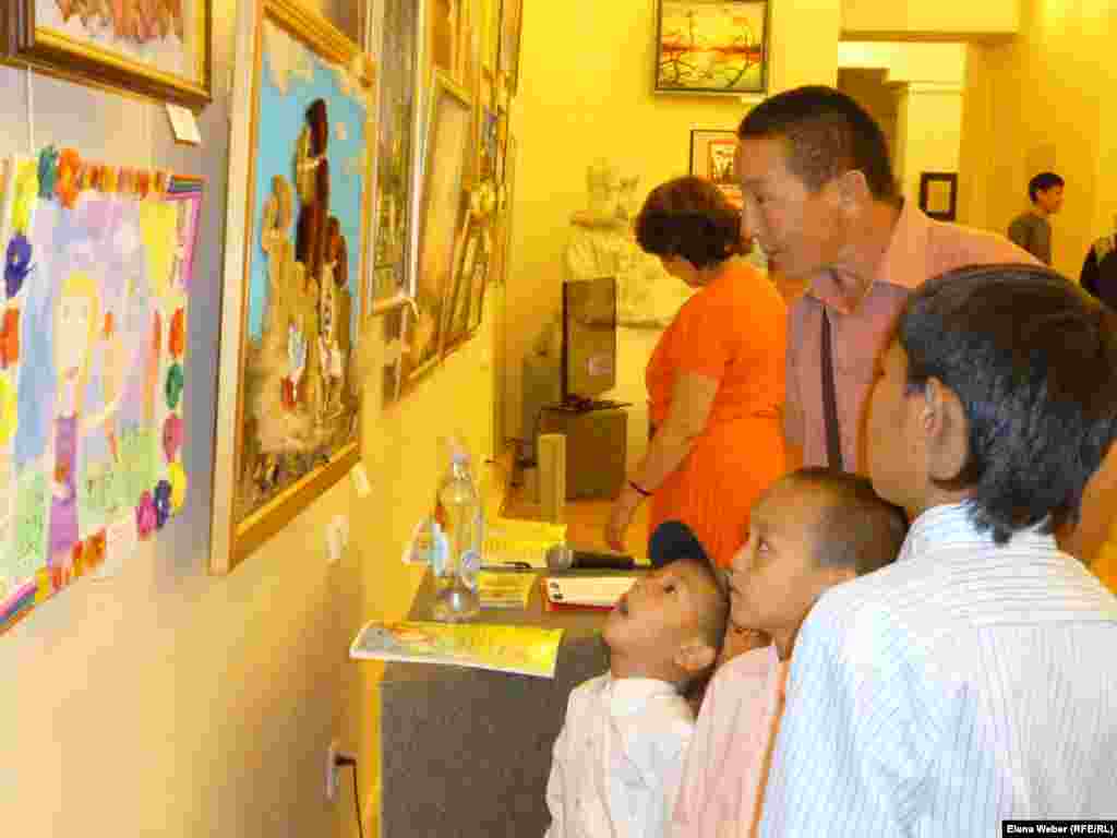 Посетители выставки разглядывают работы юных участников. &nbsp;