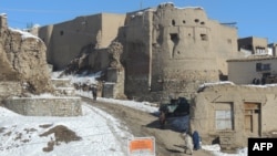 People walk past a section of the old city in Ghazni, which means "jewel."