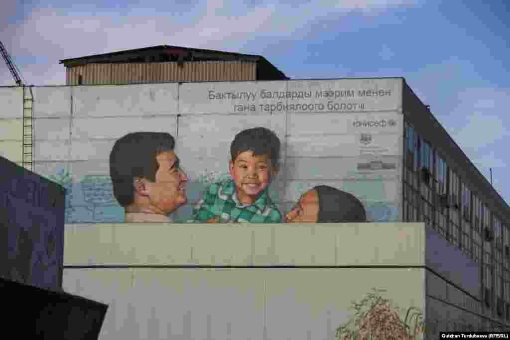 Ош базарына жакын жердеги имаратка түшүрүлгөн бул картина балдарды коргоого арналган. Тилекке каршы, жанаша курулган жаңы имарат сүрөттүн жарым жаап калган.&nbsp;&nbsp;