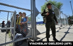 Кыргызский пограничник у ворот пограничного пункта пропуска на кыргызско-узбекской границе в Кара-Суу, примерно в 500 км к юго-востоку от Бишкека, 12 мая 2017 года.