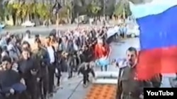 Казаки стоят у Храма Христа Спасителя в день празднования 400-летнего юбилея служения Уральского казачества Российскому государству. Фото с видеозаписи, опубликованной на сайте Ютуб.  Уральск, 15 сентября 1991 года.