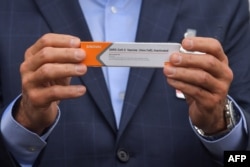 Губернатор Сан-Паулу Жоао Дориа показывает представителям СМИ упаковку вакцины CoronaVac. 19 ноября 2020 года.