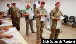 Під час голосування на виборах 2014 року (архівне фото). Україна проводила двоє виборів президента і двоє виборів Верховної Ради (в 2014 та 2019 роках) на тлі окупації Росією Криму та конфлікту на Донбасі