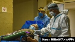 ARMENIA - A doctor wearing a protective face mask and personal protective equipment (PPE) speaks with a patient at the Grigor Lusavorich Medical Centre in Yerevan on May 27, 2020.