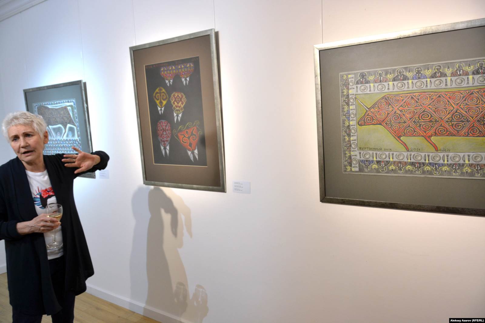 Валерия Ибраева, куратор выставки, на фоне работ «Лошадь и лошадиные силы», в центре – «Белые воротнички», справа – «Жертвенный бык», Алматы, 4 апреля 2019 года. 