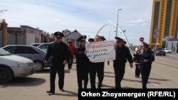 Полиция Жириновскийдің сөзіне байланысты Ресей елшілігі алдында наразылық танытқан азамат Мұратбек Арғынбековті әкетіп бара жатыр. Астана, 14 сәуір 2014 жыл. (Көрнекі сурет)