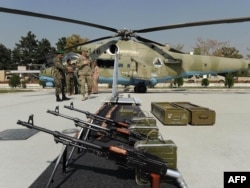 АКШлык аскер менен Ооган жоокер Ооган армиясына АКШ жана башка өлкөлөр тартуу кылган куралдарды көрүшүүдө. Ооганстандын Коргоо министрлиги Кабылда өткөргөн көргөзмө. 18-октябрь, 2011