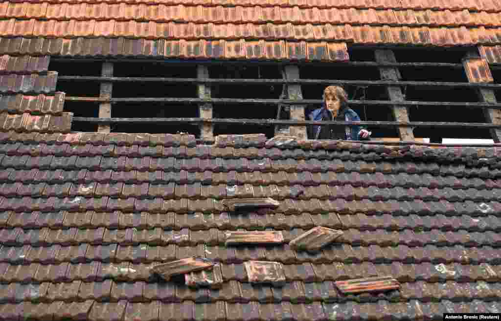 Жінка на даху пошкодженого будинку після землетрусу магнітудою 5,2 у селі Брест- Покупський. Хорватія, 28 грудня 2020 року