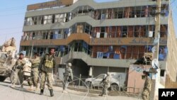 U.S. soldiers and Afghan security forces stand guard outside a Kabul Bank branch in Kandahar. (file photo)