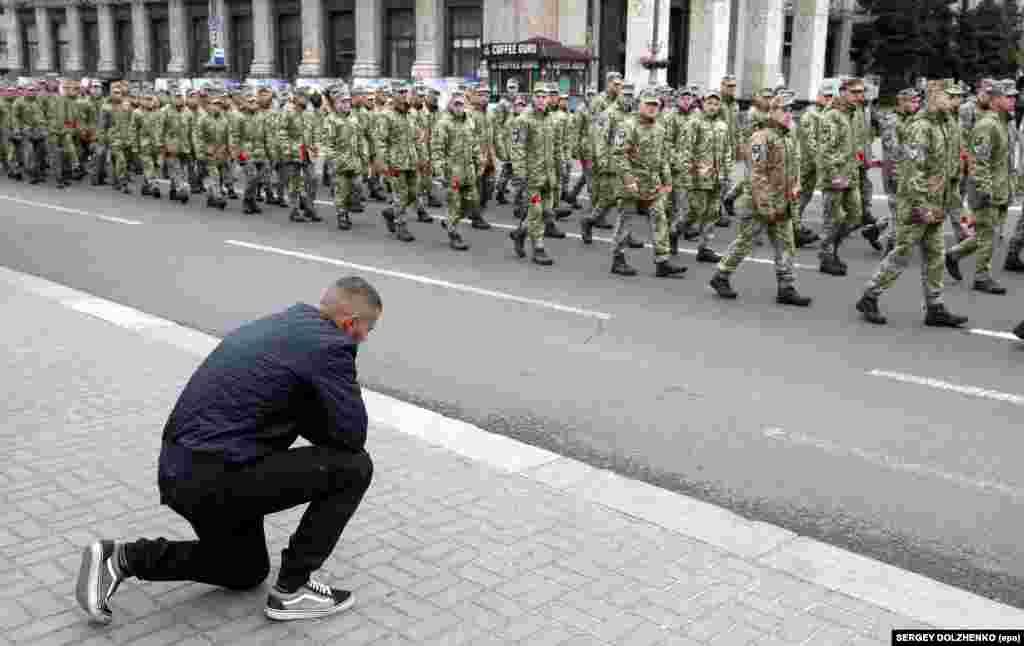 Чоловік став на коліно перед учасниками Маршу пам&#39;яті полеглих захисників України у війні з Росією на Донбасі. Київ, Хрещатик, 8 травня 2019 року. БІЛЬШЕ ПРО ЦЕ