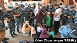 Семья Баглана Орынбекова в окружении сотрудников полицейского спецназа. Взрослых членов семьи и детей взяли в кольцо, когда они направлялись к Акорде. 25 мая 2021 года