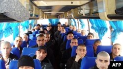 Afghan prisoners sit in a bus in Konduz on February 4, when Afghanistan and Tajikistan exchanged prisoners for the first time.