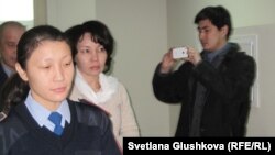 Экс-председателя агентства по статистике Анар Мешимбаеву (в центре) ведут в зал судебных заседаний. Астана, 27 января 2014 года.        
