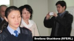 Статистика агенттігінің бұрынғы төрайымы Анар Мешімбаеваны (ортада) сотқа әкеле жатыр. Астана, 27 қаңтар 2014 жыл.   