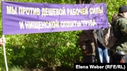 Протестующие работники компании АО "АрселорМиттал Темиртау" держат транспарант с надписью "Мы против дешевой силы и нищенской оплаты". Темиртау, 19 мая 2012 года.