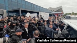 Уладзіміра Плахатнюка суправаджаюць да мікрааўтобуса, каб адвезьці з аэрапорту ў калёнію. Кішынёў, 25 верасьня 2025