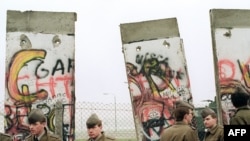 Gündogar Germaniýanyň serhetçileri Gündogar we Günbatar Berliniň arasynda geçiş nokadyny ýola goýmak üçin Berlin diwarynyň bir bölegini ýumurýarlar, 11-nji noýabr, 1989-njy ýyl. 