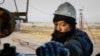 Рабочий на нефтяном месторождении в Казахстане. Иллюстративное фото.