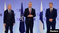 Финляндиянең тышкы эшләр министры Пекка Хаависто (сулда), саклану министры Антти Кайкконен (уңа) һәм НАТО баш секретаре Йенс Столтенберг НАТО штаб-фатирында