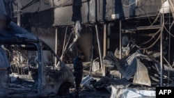 Орус армиясынын чабуулунан улам кыйрап калган имараттын урандыларынын арасында турган жергиликтүү тургун. Одесса. 8-март, 2025-жыл. 