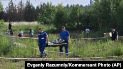 Russian law enforcement agents carry the body of former Transport Minister Roman Starovoit, who was found dead from a gunshot wound hours after his dismissal in Odintsovo, outside Moscow, on July 7.