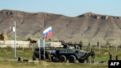 Nagorno-Karabakh - Russian peacekeepers stand next to an armored vehicle at a checkpoint near Stepanakert, October 7, 2023.