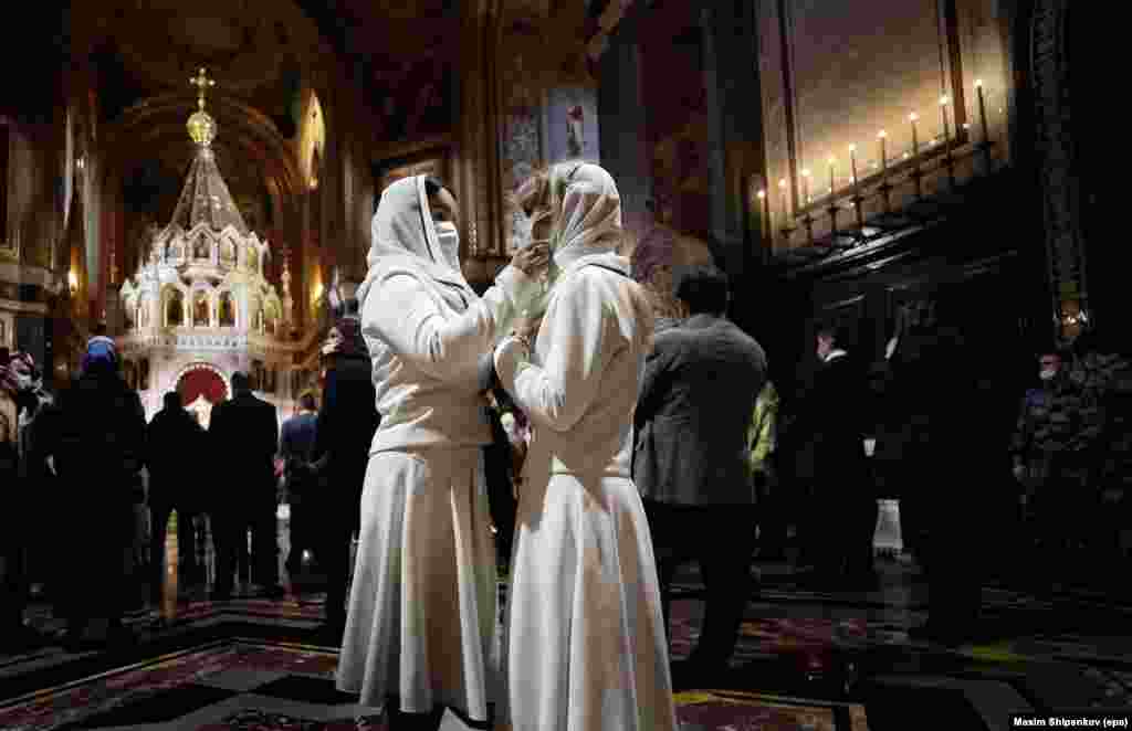 Верующие Русской православной церкви поправляют маски в храме Христа Спасителя в Москве