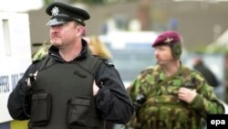 Жителям Белфаста больше не доведется увидеть на улице человека с автоматической винтовкой (на заднем плане)