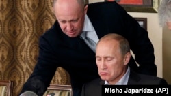 "Путиндин ашпозчусу" атыккан ишкер Евгений Пригожин (солдо) президент Владимир Путин менен. Сүрөт 2011-жылы тартылган.