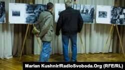 Чоловіки розглядають світлини в музеї