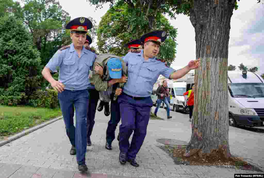 Полиция задерживает мужчину во время мирной акции протеста 10 июня. Алматы, Казахстан. (Petr Trotsenko, RFE/RL)