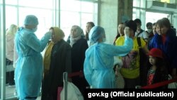 Медицина кызматкерлери чек арадан өтүп жаткан адамдардын дене табын өлчөп жатат. "Манас" аэропорту. Февраль, 2020-жыл. 12-мартта өкмөт коронавирус коркунучуна байланыштуу маданий, спорттук жана башка массалык иш-чараларды өткөрүүгө убактылуу чектөө киргизген.