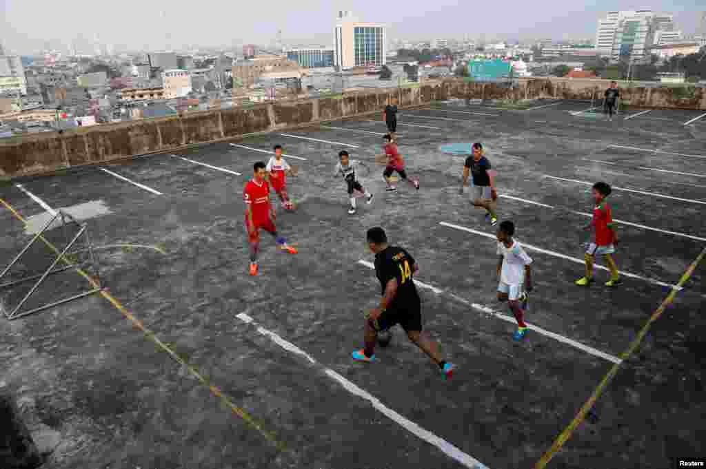 Дети играют в футбол на крыше гаража в Джакарте. Индонезия, 4 мая 2018 года.
