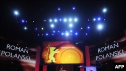 Берлин фестивалында Роман Поланский (деген жазуу) көрөрмандарды кире бериштен эле каршы алды.