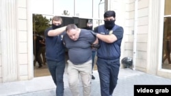 Sputnik Азербайжан агенттигинин башкы редактору Евгений Белоусов кармоо учурунда. Баку, 30-июнь 2025-жыл