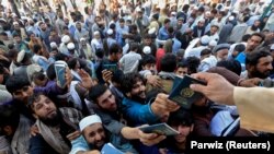 آرشیف- افغانهای که قصد سفر به پاکستان دارند می خواهند پاسپورت های خود را به مسئول سفارت پاکستان تحویل کنند