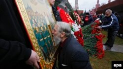 Відзначення дня народження Йосипа Сталіна на його могилі біля Кремлівської стіни на Червоній площі. Чоловік цілує ікону із зображенням радянського диктатора. Москва, 21 грудня 2015 року