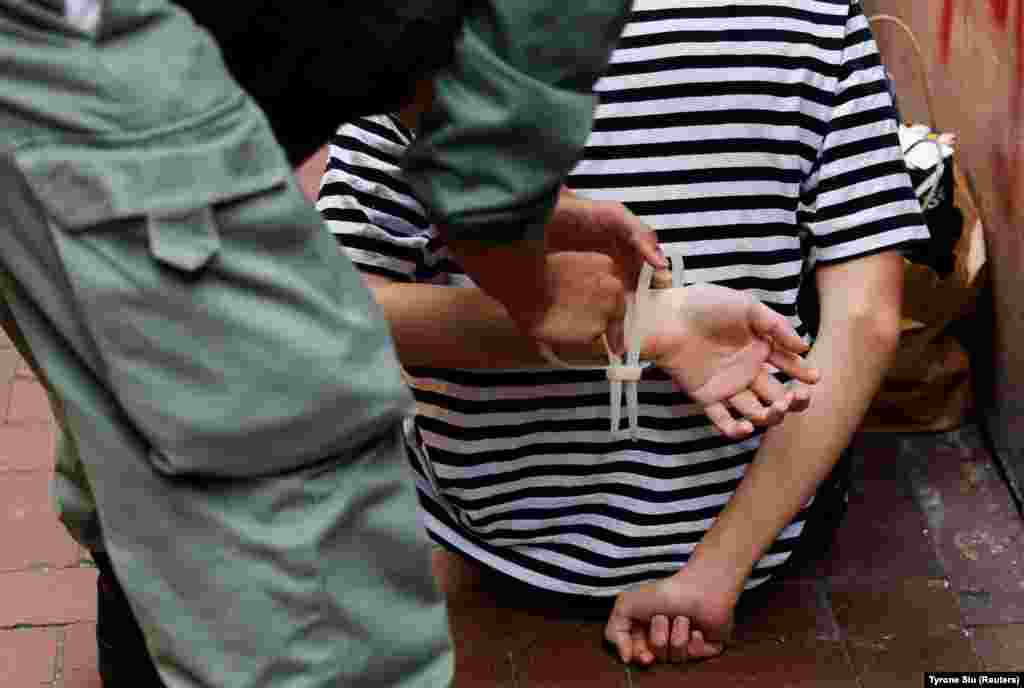 Поліція зв&rsquo;язує руки протестувальника кабельною стяжкою під час ходи проти нового закону про нацбезпеку в Гонконгу 1 липня