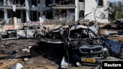 Згорілі автомобілі та пошкоджена будівля на місці падіння ракетного удару Ірану по Ізраїлю в Беер-Шеві, Ізраїль, 20 червня 2025 року