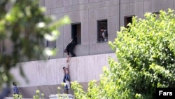 Чоловік допомагає спустити дитину з будівлі парламенту Ірану через вікно, Тегеран, 7 червня 2017 року