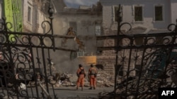 Рятувальники на місці одного з попередніх російських ударів по Сумах, 14 квітня 2025 року