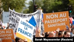 Парижде демонстранттар атайын медициналык маалымдама киргизүүгө каршы плакаттарды көтөрүп чыгышты. 31-июль, 2021-ж.