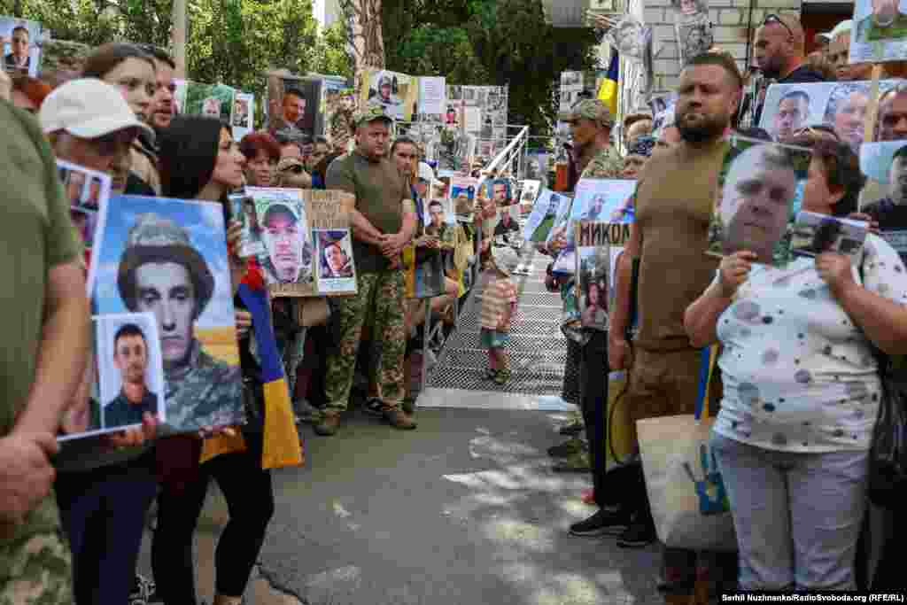 Але є й ті, хто не дочекався сьогодні своїх рідних...Довгим коридором, тримаючи в руках фото своїх рідних і побратимів, шикуються вони, щоб звільнені змогли пройти ним. Можливо їм вдасться упізнати когось на фото і розповісти рідним про їхніх батьків, чоловіків, синів і доньок