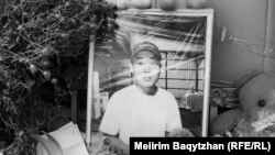 Кісі қолынан мерт болған жасөспірім Шерзаттың суреті қойылған жерге жұрт гүл әкеліп, плакатқа марқұмға арнау сөздер жазған. Алматы облысы Талғар қаласы, 14 қазан, 2024 жыл.