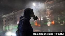 ფოტო არქივიდან. აქციის მონაწილეები პოლიციის მიერ გაშვებული ცრემლმდენი აირისგან თავს აირწინაღებით იცავენ. 2024 წლის 6 დეკემბერი