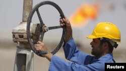 Мұнай құбырын тексеріп жүрген жұмысшы. Ирак,  8 қыркүйек 2012 жыл.