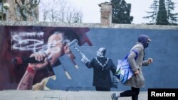 Дубалда "Пабло Хаселге боштондук!" деп жазылган жана аны мурдагы падыша Хуан Карлос өчүрүп жаткандай тартылган.  Автор - Синта Видал айым. Кардедеу кыштагы. Каталония. 2021-жылдын 15-февралы.